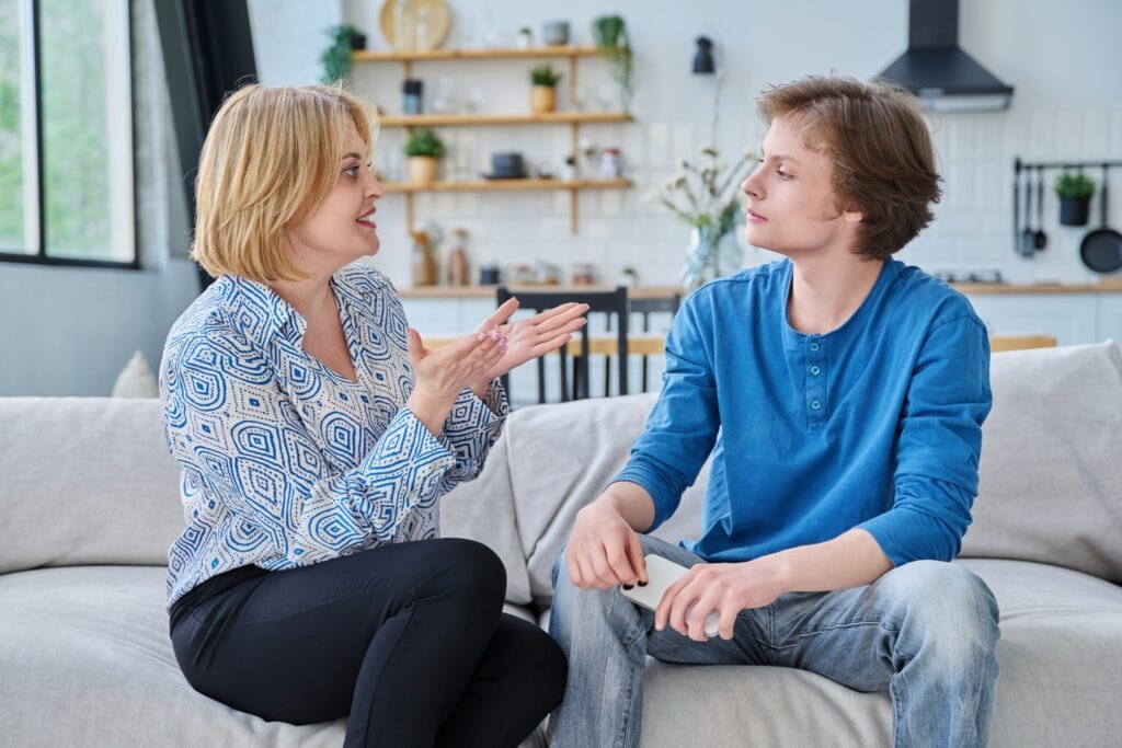 Mutter und Sohn besprechen zu Hause die Ausgehzeiten am Abend