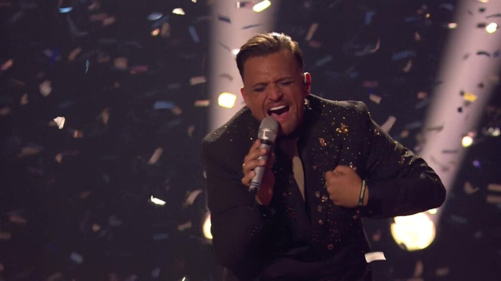 DSDS Gewinner 2026 Menowin Fröhlich singt leidenschaftlich auf der Bühne, während Konfetti den Siegesmoment untermalt