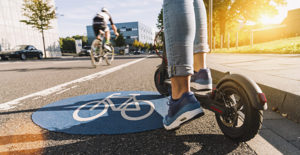 E-Scooter rollt über einen markierten Radweg mitten in der Stadt