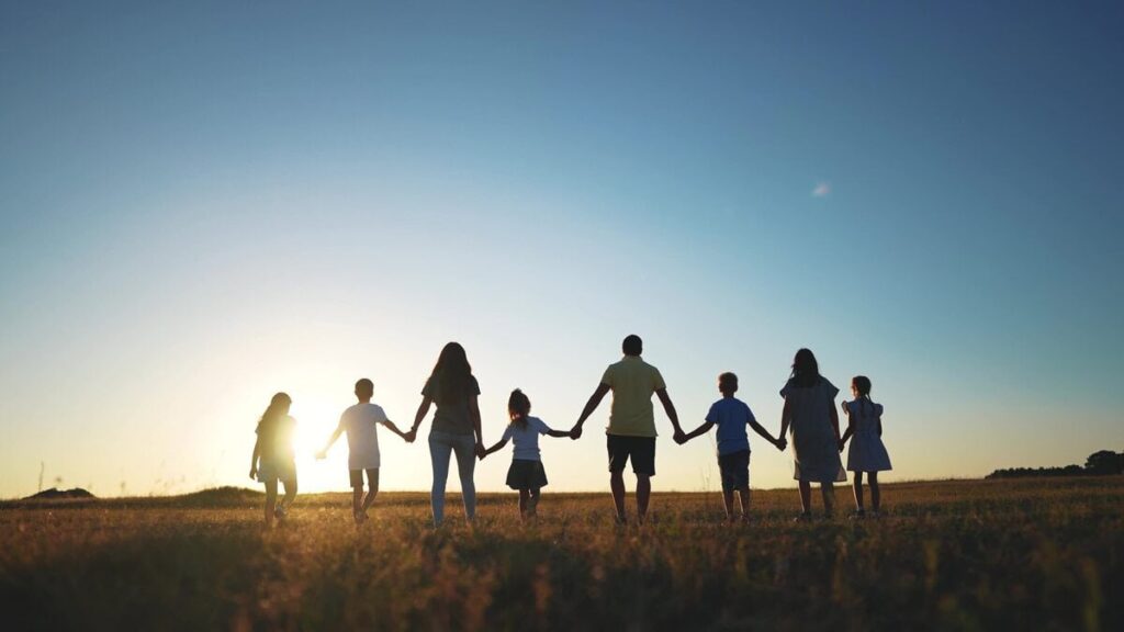 Große Familie als Silhouette im Sonnenuntergang, ein Motiv rund um die Vielehe