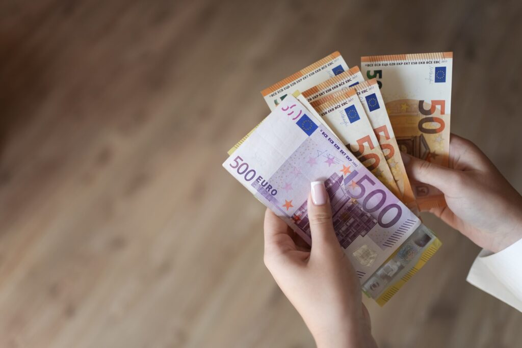 Hände zählen Euroscheine für die Kosten des Führerscheins Klasse AM