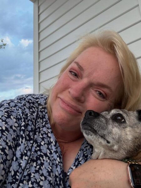 Janelle Brown von Alle meine Frauen lächelt heute mit ihrem Hund