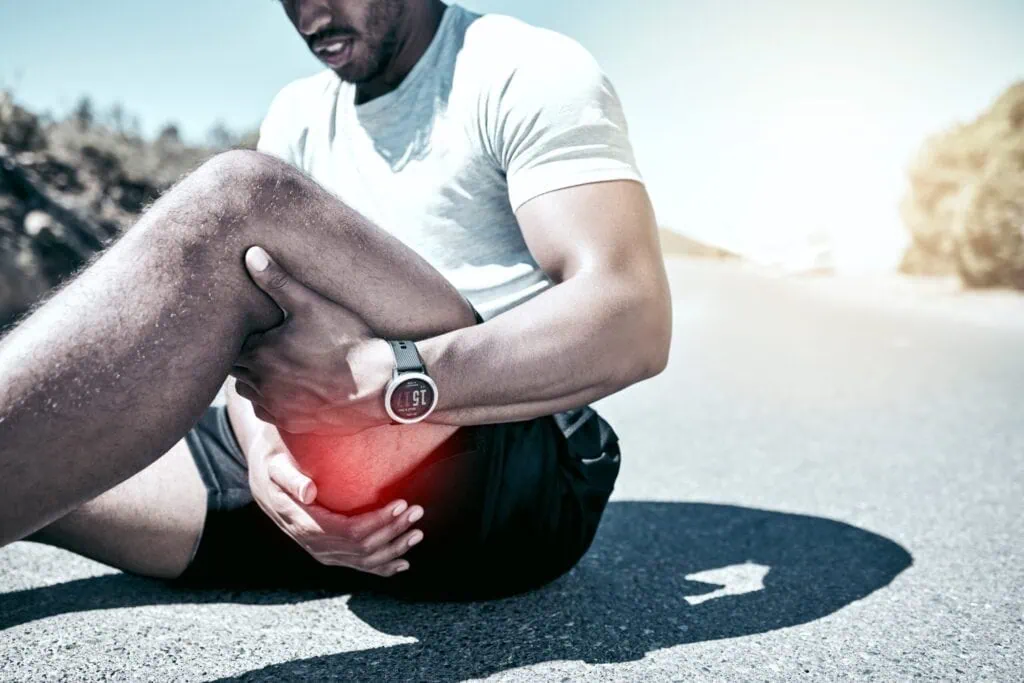 Mann hält sein schmerzendes Knie, dahinter steckt eher eine Verletzung als Muskelkater