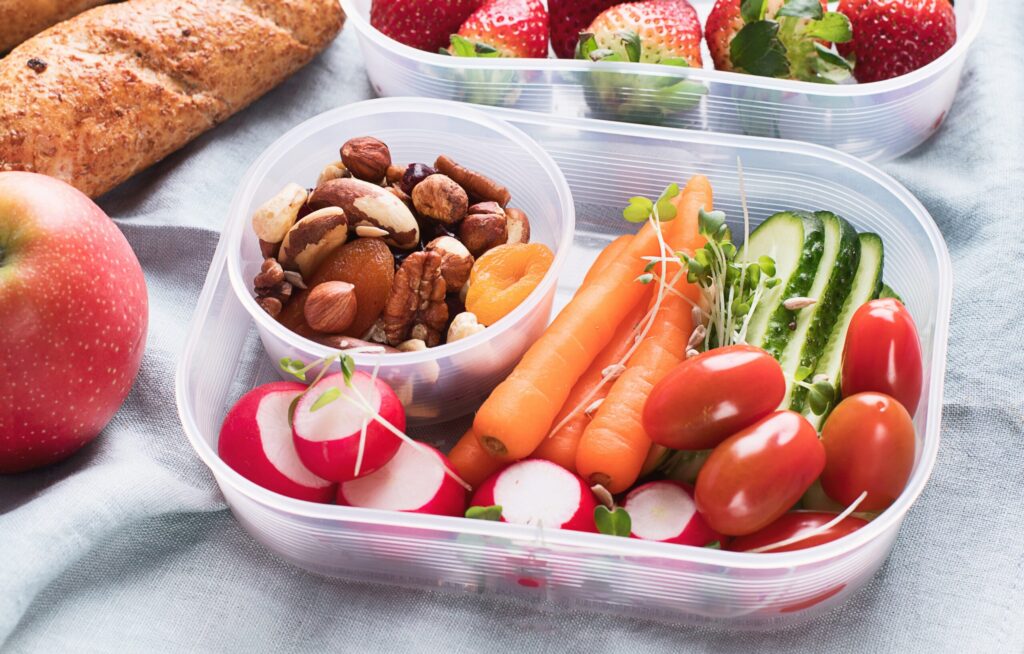 Brotzeitbox mit Nüssen, Obst und Gemüse als feste Snacks fürs Flugzeug