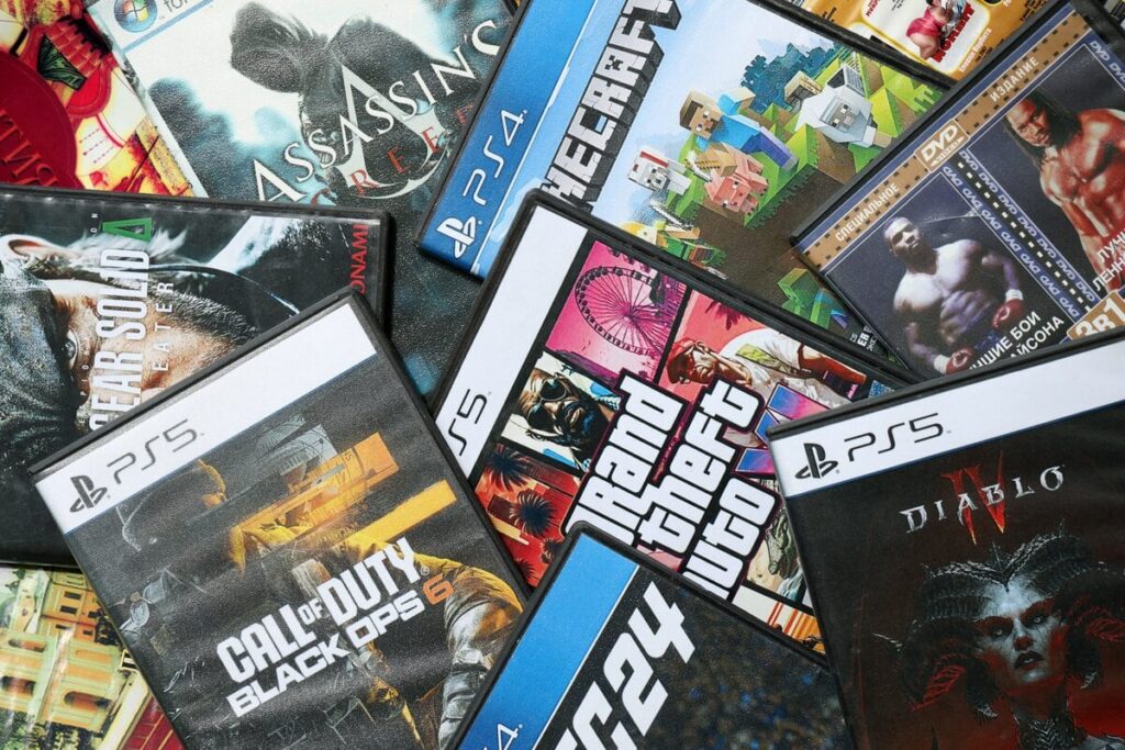 Ein Stapel physischer PlayStation-Spiele mit dem GTA-Cover obenauf.