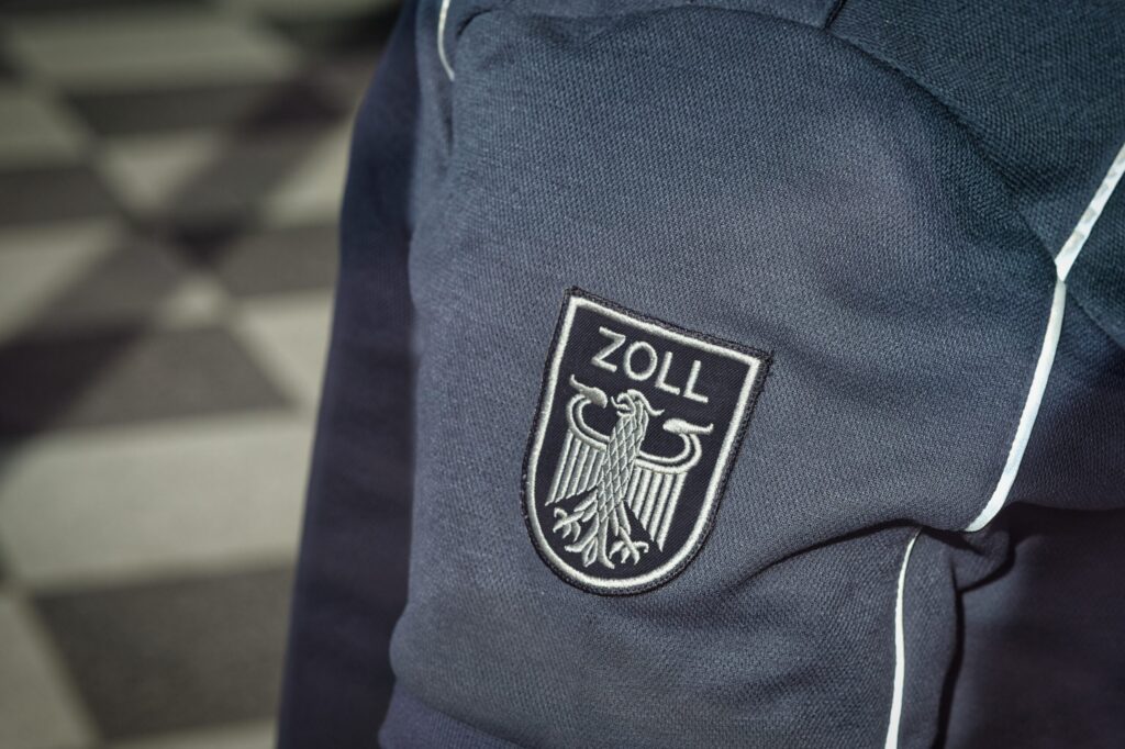 Nahaufnahme des Zoll-Abzeichens auf der Uniform bei der Einreisekontrolle